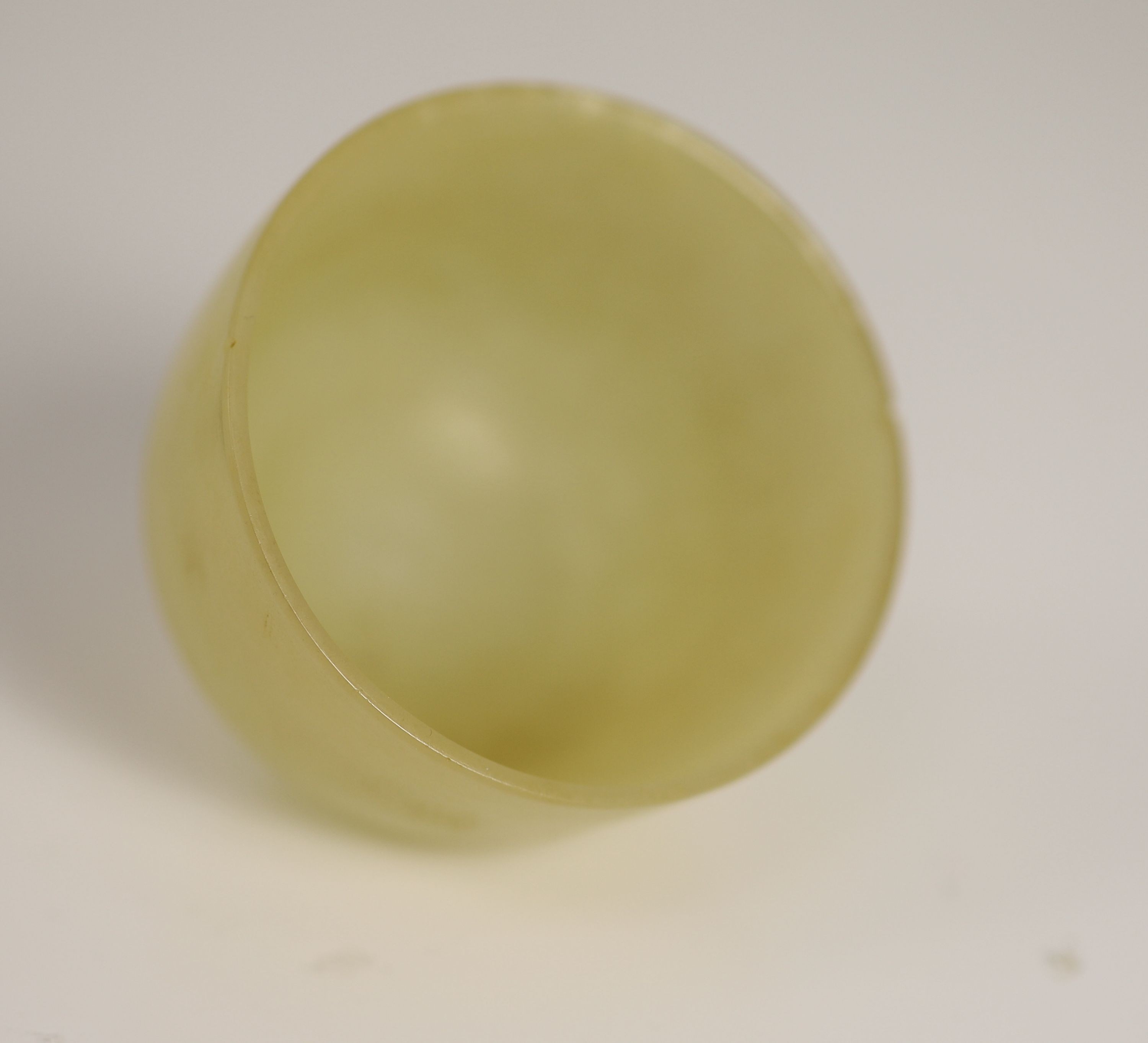 A Chinese yellow hardstone cup, 19th century, 5cm diameter, wood stand, rim chip